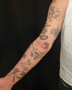 a man's arm with flowers and butterflies tattooed on the left side of his arm