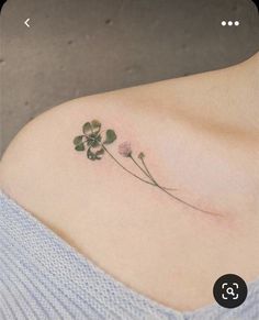 a four leaf clover tattoo on the left side of the shoulder, with three leaves attached to it