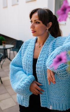 a woman wearing a blue knitted jacket