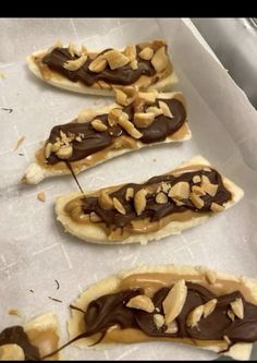 four pieces of food with chocolate and nuts on them