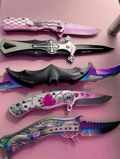 several different types of knifes on a pink counter top with one being cut open