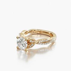 a yellow gold engagement ring with an oval cut diamond in the center and side stones on each band