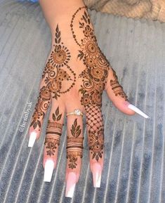 a woman's hand with henna tattoos on it