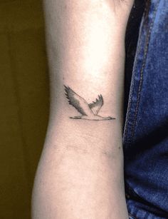 a small bird tattoo on the wrist