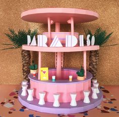 a paper model of a pink carousel with palm trees