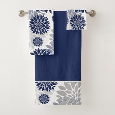 two towels hanging on a towel rack with blue and white flowers in the middle,