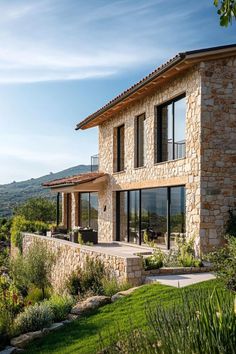 a large stone house sitting on top of a lush green hillside