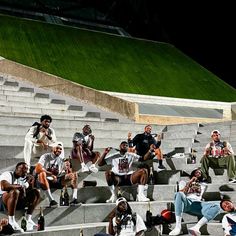 a group of people sitting on the bleachers in front of some stairs with beer bottles