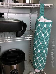 a crocheted bag sitting on top of a shelf next to an electric cooker