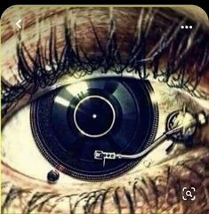 an eye with the reflection of a record player in it's irise,