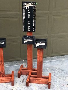 two wooden stands with signs on them in front of a garage