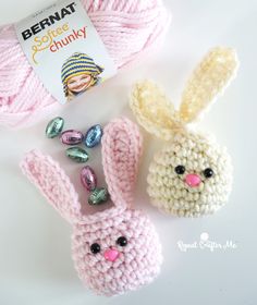 two crocheted bunny bunnies next to a ball of yarn and some candy