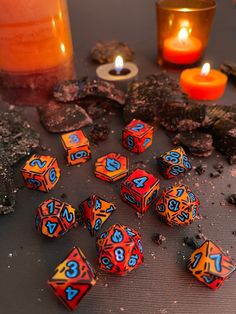 the dices are sitting on the table next to some candles and other things in front of them