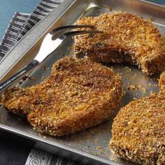 four pieces of fried food on a pan with a fork and knife next to it