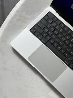 an open laptop computer sitting on top of a white table