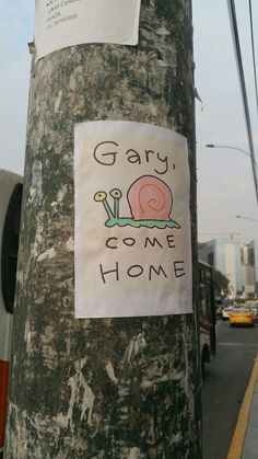 a sticker on the side of a pole that says, gay come home with a snail