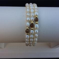 Cultured Freshwater Pearls, Tiger Eye, And Goldtone Beads Memory Wire Bracelets. Since Pearls And Gemstones Are Natural Materials, There Are Natural Differences In Each. Approx. 55mm In Diameter. Approx. 4-5mm Pearls, 2mm Goldtone Beads, And 4mm Gemstones. White Single Strand Beaded Bracelet For Gift, White Pearl Jewelry With Gemstone Beads, White Pearl Bracelet With Natural Stones For Wedding, Adjustable White Pearl Necklace With Natural Stones, Adjustable Hand-strung White Pearl Necklace, White Pearl Beaded Bracelets With Natural Stones, White Beaded Bracelets With Pearl Drop, White Single Strand Pearl Beaded Bracelet, White Round Beaded Single Strand Bracelet