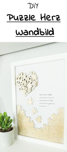 the diy puzzle heart wall art is displayed next to a potted succulent