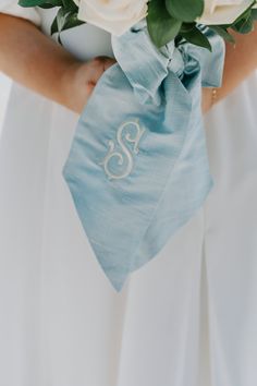 a bride holding a bouquet of flowers in her hands with the letter s on it