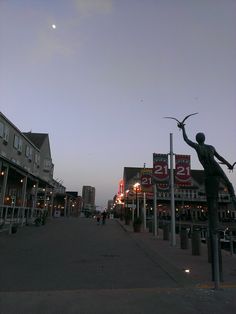 a statue is standing in the middle of an empty city street at dusk with no people on it