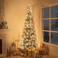 a lit christmas tree in front of a window with presents on the floor next to it