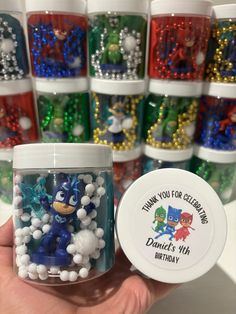 a person holding a jar filled with lots of beads