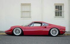 a red sports car parked in front of a white building