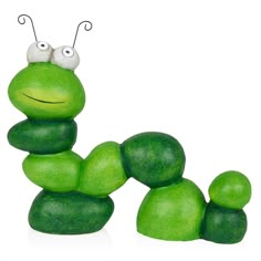 a green toy with two eyes sitting on top of it's head and legs