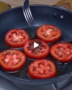 tomatoes being cooked in a skillet on the stove