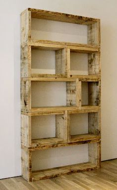 a wooden shelf sitting on top of a hard wood floor next to a white wall