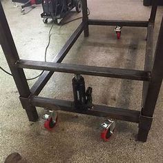 there is a metal frame with red wheels on the floor