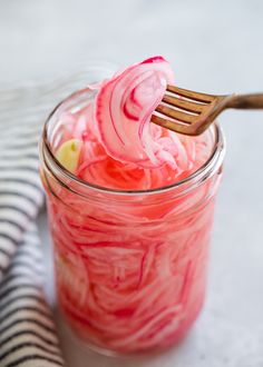 a jar filled with pink jello and a wooden fork