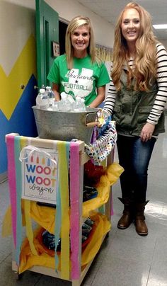 two girls standing next to a large metal bucket filled with ice cream and candy canes