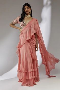 Peach pre-draped saree with ruffle detailing. Comes with embroidered padded blouse.
Component: 2
Pattern: Embroidery
Type Of Work: Floral
Neckline: Plunge V
Sleeve Type: Half
Fabric: Organza, Net, Lining: Cotton Shantoon
Color: Peach
Other Details: 
Fitted at bust and waist
Note: The neckpiece worn by the model is not for sale
Occasion: Wedding - Aza Fashions Fiji Outfits, Cotton Sarees Handloom, Pretty Dresses Casual, Peach Saree, Draped Saree, Organza Embroidery, Ruffle Saree, Padded Blouse, Drape Saree