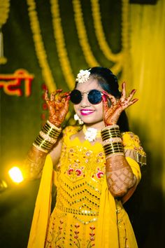 a woman dressed in yellow and holding her hands up