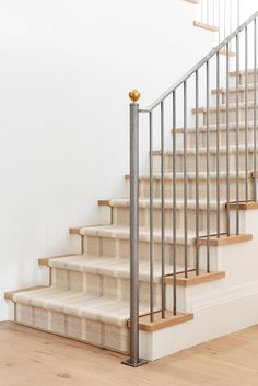 a set of stairs with metal handrails and carpeted steps in an empty room