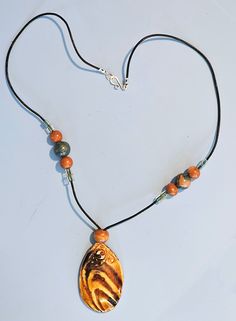 A perfect one-of-a-kind gift for yourself or someone special such as your mother, daughter, grandmother, wife, or friend. Especially for lovers of handmade ceramic jewelry. This elegant hand-crafted ceramic necklace has a glazed porcelain pendant that is 1 3/4" x 1". It is strung on a black leather cord.  The closure is a sterling silver hook and loop.  The necklace is 18" long.  Other materials include polymer clay, wood, and glass beads. This unique jewelry piece is the perfect accessory for daytime or evening wear. Each pendant is hand made by me using molds I have created. There may be some imperfections that makes it unique. If you have any questions, please don't hesitate to ask. NOTE: Ceramic necklaces may be breakable if dropped on a hard surface. This item is ready-to-ship. All ou Nature-inspired Brown Beaded Necklaces As Gift, Nature-inspired Brown Beaded Necklace For Gifting, Nature-inspired Brown Beaded Necklace For Gifts, Nature-inspired Brown Beaded Necklace Gift, Unique Hand Painted Brown Necklace, Artistic Adjustable Brown Necklace, Artistic Brown Necklace For Gift, Adjustable Brown Artistic Necklace, Brown Artsy Jewelry For Gifts