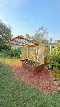 a garden area with a wooden structure and plants in it