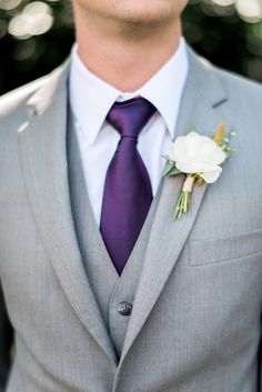 a man wearing a gray suit and purple tie