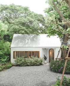 a white house surrounded by greenery and trees