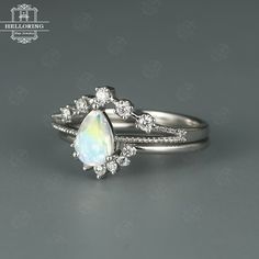 a white opal and diamond ring set on top of each other with an oval shaped stone