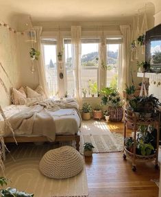 a bed room with a neatly made bed and lots of plants on the windowsill