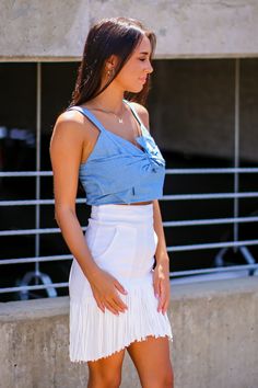 Details: Chambray crop top with bow detail and smocked back- Chambray - Bow detail - Smocked back Content: -100% Rayon Size + Fit- Model is 5'4" and wearing a Small- Measurements from a size small- Full length: 15"- Chest: 32"- Waist: 28" Sleeveless Cotton Top With Bow Tie Back, Spring Fitted Crop Top With Bow Tie Back, Spring Tops With Bow Tie Back For Day Out, Casual Sleeveless Top With Bow Tie Back, Trendy Crop Top With Built-in Bra For Day Out, Spring Beach Tops With Bow Tie Back, Chic Tie Back Crop Top For Day Out, Chic Summer Crop Top With Bow Tie Back, Spring Chic Cotton Crop Top