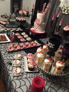 a table topped with cakes and cupcakes on top of a black table cloth