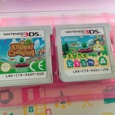 two nintendo wii games sitting next to each other on a pink plastic case in front of a colorful background