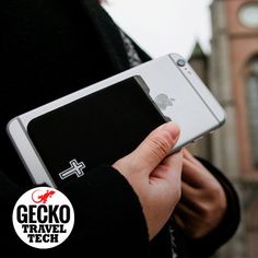 a person holding an electronic device with a cross sticker on the back of it