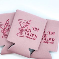 three pink can coolers with the words tintin older written on one side