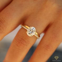 a woman's hand with a diamond ring on top of her finger and an engagement band