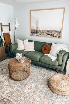 a living room with green couches and rugs in front of a painting on the wall