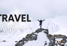 a man standing on top of a snow covered mountain with his arms in the air